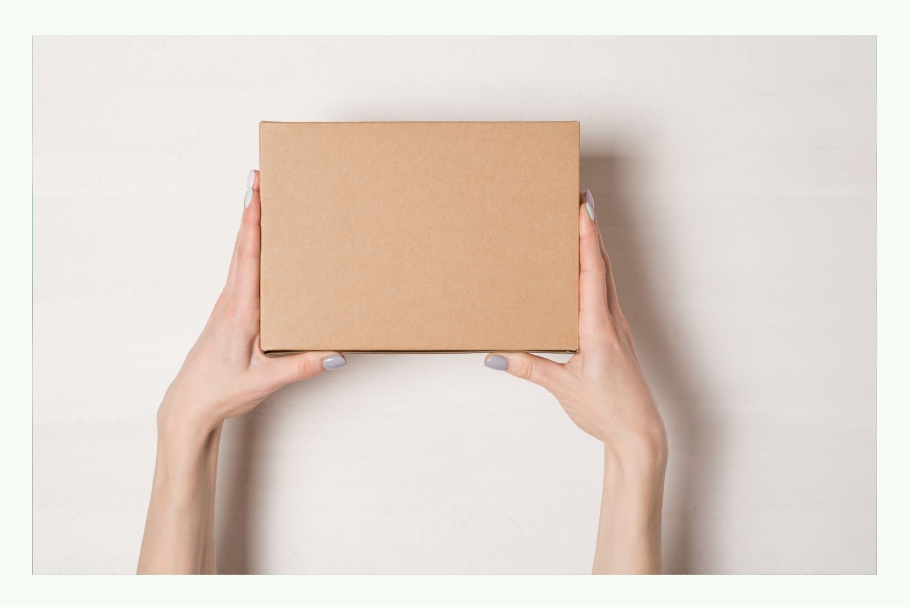 Two hands holding a brown cardboard box Two hands holding a brown cardboard box