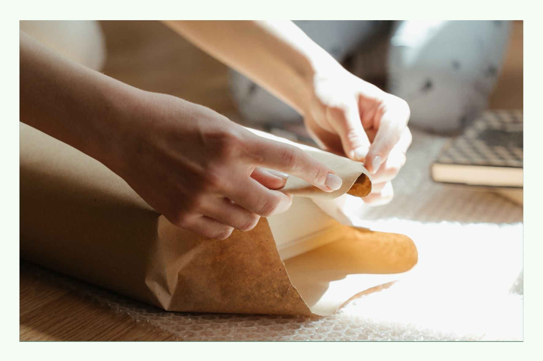 Hände falten braunes Papier für eine Verpackung