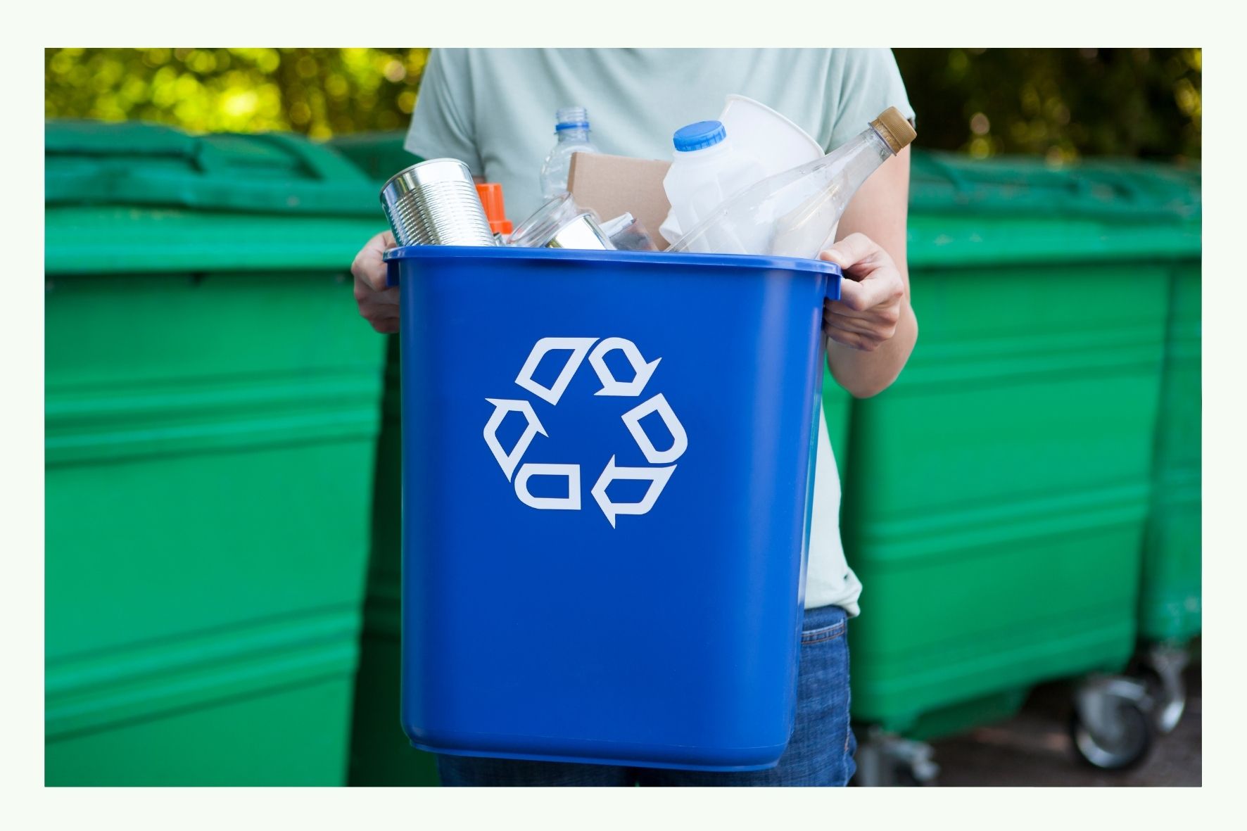 Person holding a blue recycling bin with symbol Person holding a blue recycling bin with symbol