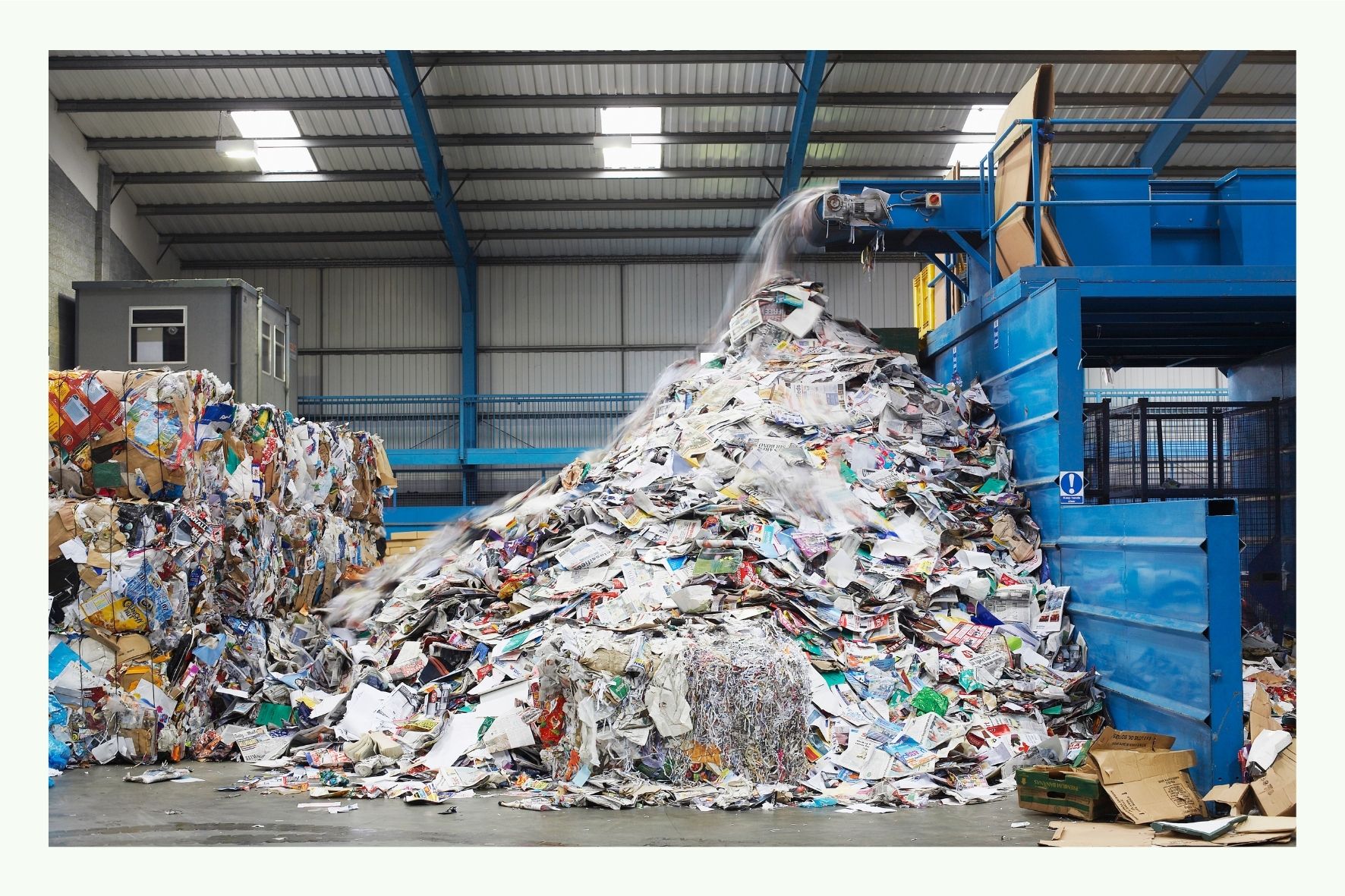 Großer Haufen Abfall vor Recyclinganlage in einer Halle